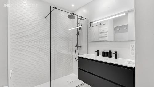 une salle de bain avec une douche en verre et un lavabo dans l'établissement Le Segoffin, à Toulouse