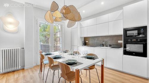 - une cuisine blanche avec une table à manger et des chaises dans l'établissement Le Segoffin, à Toulouse