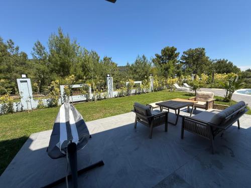 a patio with a table and two chairs and a table and benches at Canyon Villa Göynük Kemer Antalya with Pool in Antalya