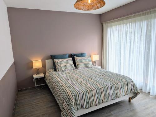 - une chambre avec un lit avec deux oreillers et une fenêtre dans l'établissement Le Pastis - Direct aan het strand en het centrum - Top locatie!, à Cavalaire-sur-Mer