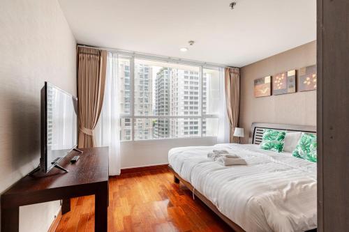 a bedroom with a large bed and a large window at 2 BR in Downtown BTS Chitlom BKK in Bangkok