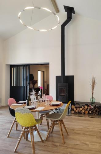 une salle à manger avec une table et des chaises et une cheminée dans l'établissement Magnifique gîte écologique en pleine campagne avec piscine, à Pont-du-Casse