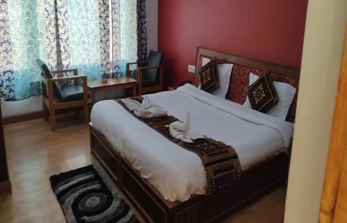 a bedroom with a bed and a red wall at The Kurja Garden in Leh