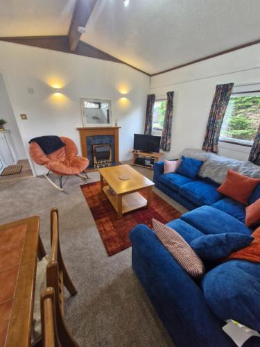 a living room with a blue couch and a table at 57 penlan holiday park in Cenarth