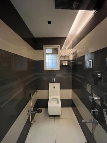 a bathroom with a toilet and a window at Zenith Luxe Suites - Near IIT & Hiranandani, Powai in Mumbai