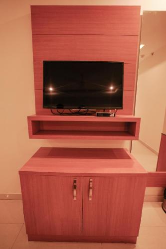 a entertainment center with a television on a wall at Hotel Indriya Wayanad in Kalpetta