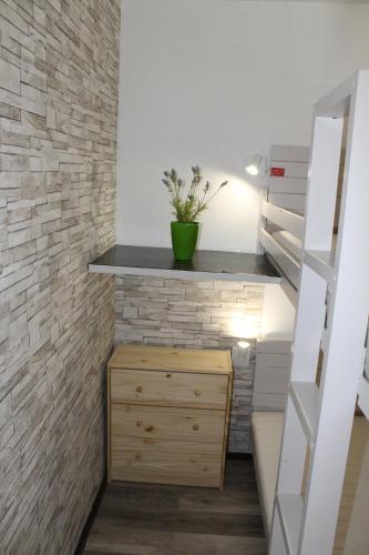 Cette chambre dispose d'une commode en bois et d'un mur en briques. dans l'établissement Appartement Superdevoluy avec vue sur les pistes et montagne, à Saint-Étienne-en-Dévoluy