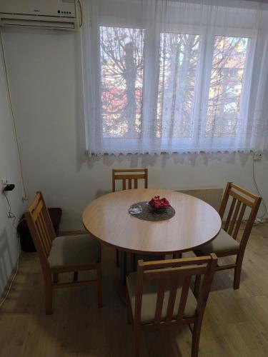 a table and chairs in a room with a window at R & P Apartman Mladenovac in Mladenovac
