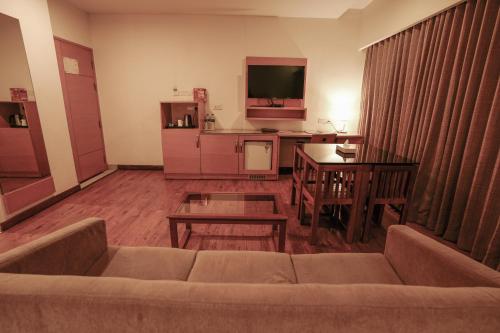 a living room with a couch and a table at Hotel Indriya Wayanad in Kalpetta