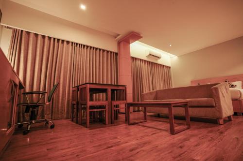 a living room with a couch and a table at Hotel Indriya Wayanad in Kalpetta