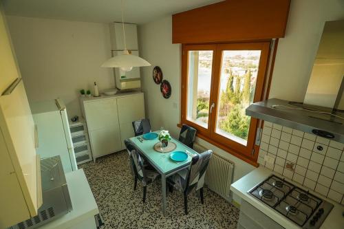 a kitchen with a table with chairs and a window at Panoramic Lake View Apartment in Nago-Torbole