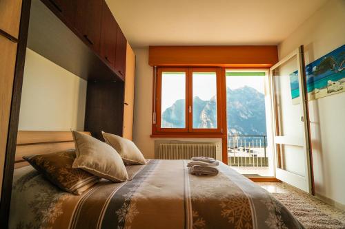 a bedroom with a large bed with a large window at Panoramic Lake View Apartment in Nago-Torbole
