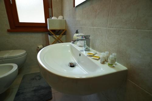 a bathroom with a sink and a toilet at Panoramic Lake View Apartment in Nago-Torbole