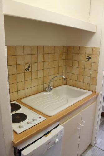 une cuisine avec un évier et une cuisinière dans l'établissement Appartement Superdevoluy avec vue sur les pistes et montagne, à Saint-Étienne-en-Dévoluy