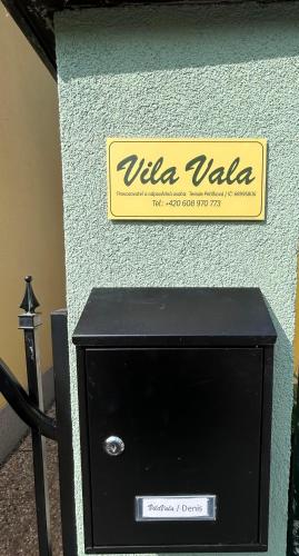 a sign on the side of a wall with a black box at VilaVala in Nymburk
