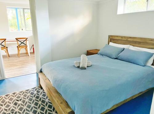 a bedroom with a bed with a stuffed animal on it at Bruns Beach Garden Apartment - Central, Comfortable & Close to the beach in Brunswick Heads