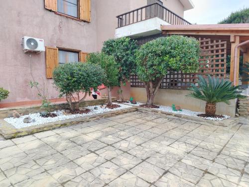 a courtyard with trees in front of a building at La Finestra Sul Mare in Stintino