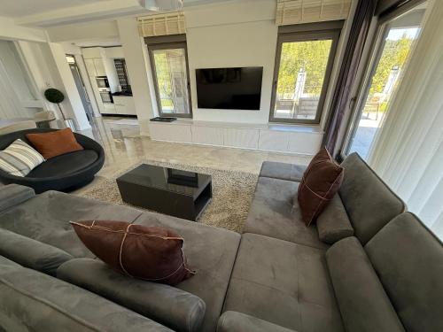 a living room with a couch and a tv at Canyon Villa Göynük Kemer Antalya with Pool in Antalya