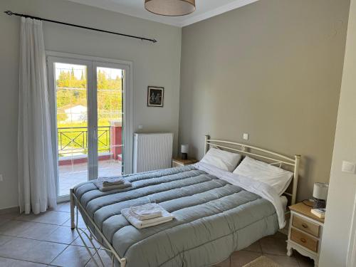 a bedroom with a bed and a large window at Bruskos Holiday Deluxe in Kynopiástai