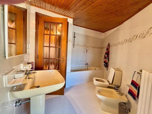 a bathroom with a sink and a toilet and a tub at Casa FiorElena in Gargnano