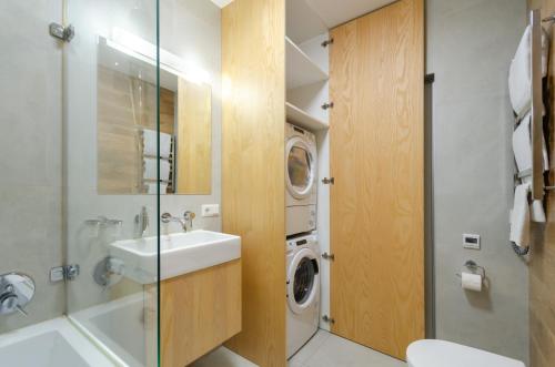 a bathroom with a sink and a washing machine at Petrovdom 129-179-191-131 in RC Nivki Park Space Meets Comfort in Kyiv