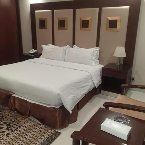 a bedroom with a large bed and a table at منتجع شاطئ الدولفين للإيواء السياحي in Yanbu