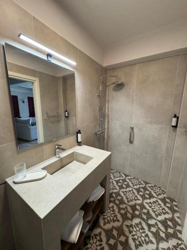 a bathroom with a sink and a mirror at Antalki Experience Apartments in Papigko