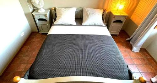 - un lit dans une petite chambre avec 2 tables de nuit dans l'établissement Le Beau Coin, à Serviès-en-Val