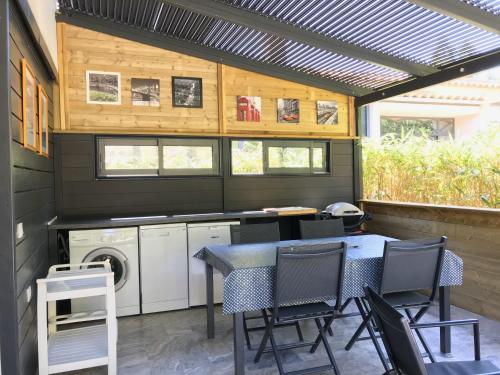 d'une terrasse avec une table et des chaises, ainsi que d'un lave-linge et d'un sèche-linge. dans l'établissement Gite Vanisa, à Sainte-Maxime
