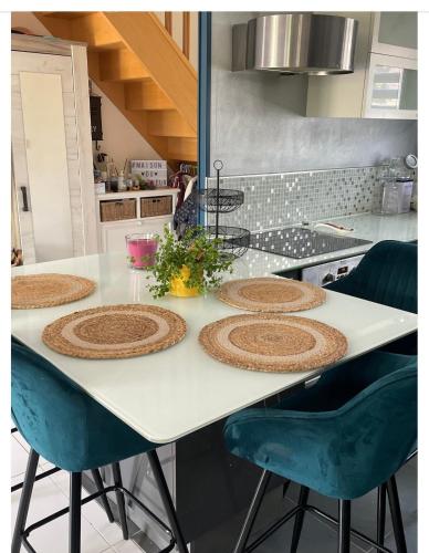 une cuisine avec une table et des chaises bleues dans l'établissement Maison proche du circuit des 24h du Mans, à Ruaudin