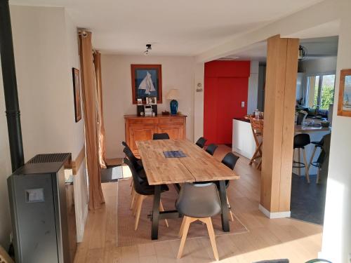 une cuisine et une salle à manger avec une table et des chaises en bois dans l'établissement Grande maison sur propriété près de la plage de Morgat, à Crozon