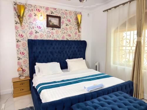 a blue bed in a room with a window at JM Furnished Kampala Entebbe Rd B in Lubowa