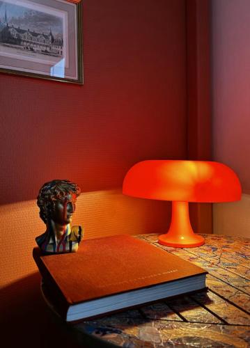a chair and a book on a table with a lamp at Un petit Air de Campagne -4km d'Amboise in Chargé