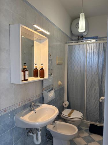 a bathroom with a sink and a toilet and a mirror at FILANGERI 116 in Santa Flavia