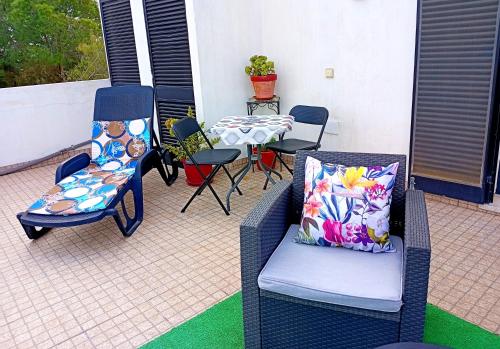 a patio with chairs and a table and a table and chairs at Bohème Valdareina, Piscine chauffée, Bénagil-Carvoeiro in Carvoeiro