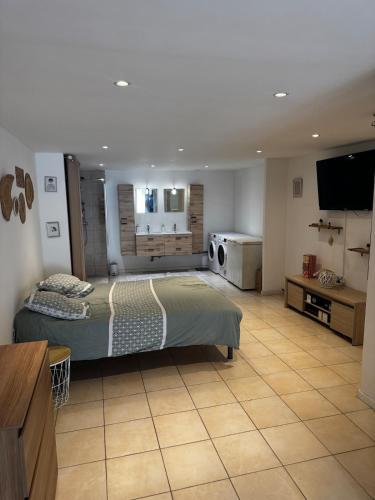 une chambre avec un lit et une télévision à écran plat dans l'établissement Maison proche de la plage, à Saint-Laurent-de-la-Salanque