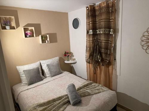 une chambre avec un lit avec une couverture dessus dans l'établissement T2 Montpellier plein sud clim wifi terrasse de 16m2, à Montpellier