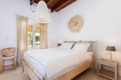Un dormitorio con una gran cama blanca y una ventana. en YourHouse Calimero Villa, en Pòrtol