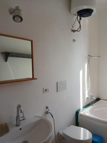 a bathroom with a sink and a toilet and a mirror at Casa al Vallone in Alicudi