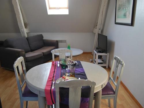 un salon avec une table avec des chaises et un canapé dans l'établissement Gîte L'Arquebuse, à Troyes