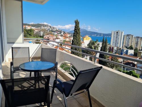 ein Balkon mit Tisch und Stühlen und Blick auf die Stadt in der Unterkunft NataLena in Igalo