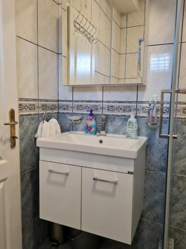 Un baño con un lavabo blanco y un espejo. en NataLena, en Igalo