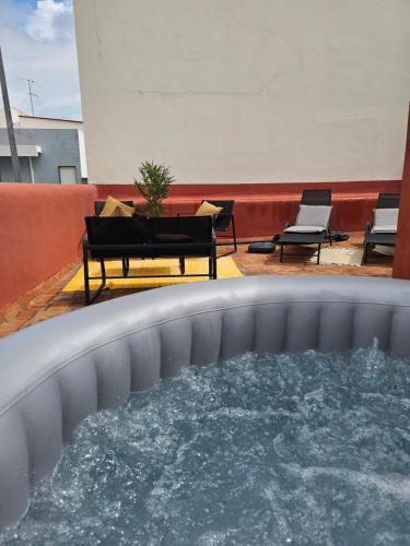 a hot tub on the roof of a building with chairs at City Center Terrace in Faro