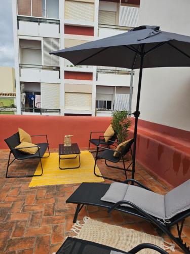 a patio with chairs and an umbrella on a building at City Center Terrace in Faro