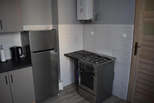a small kitchen with a stove and a refrigerator at AGNESx in Przemyśl