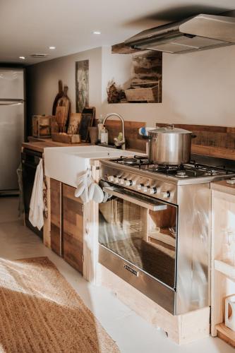 - une cuisine avec cuisinière et pot dans l'établissement La Petite Grange des Vignes, à Jumilhac-le-Grand