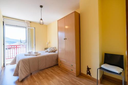 a bedroom with a bed and a large window at Ca l'Agnès in Oliana