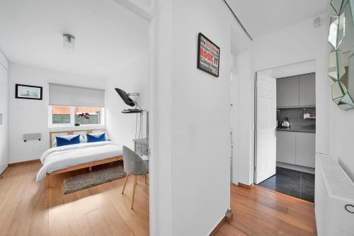 a bedroom with a bed and a desk in a room at The Cosy Flat in Bethnal Green in London
