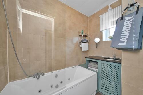 a bathroom with a bath tub and a sink at The Cosy Flat in Bethnal Green in London