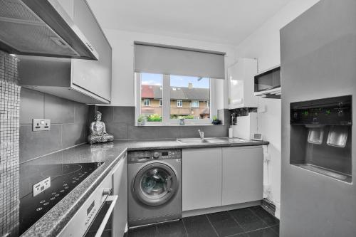 a kitchen with a washing machine and a sink at The Cosy Flat in Bethnal Green in London